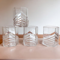 Set of clear glass hexagonal vases on a light surface with a neutral background