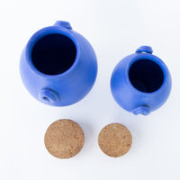 Two Bright Blue Ceramic Canisters with Handles and Cork Tops