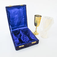 Two matching brass champagne flutes in a blue velvet box