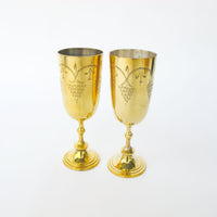 Two matching brass champagne flutes in a blue velvet box
