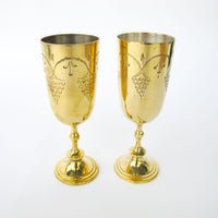 Two matching brass champagne flutes in a blue velvet box