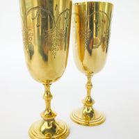 Two matching brass champagne flutes in a blue velvet box
