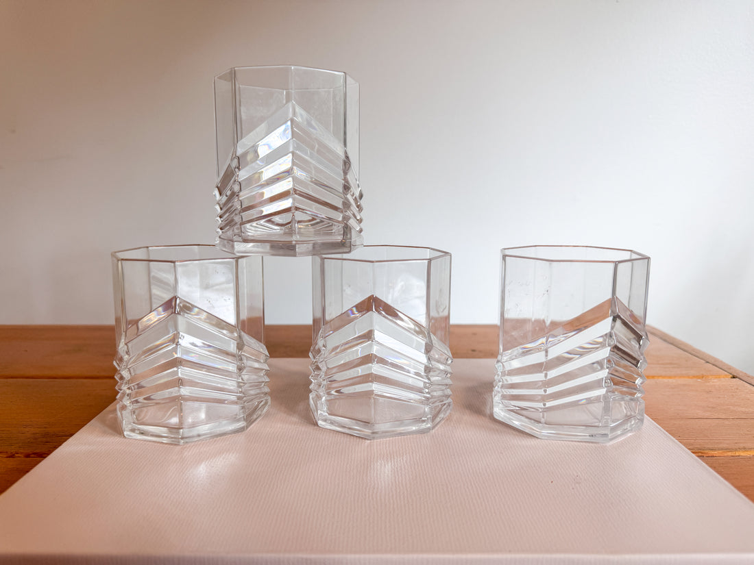 Set of clear glass hexagonal vases on a light surface with a neutral background