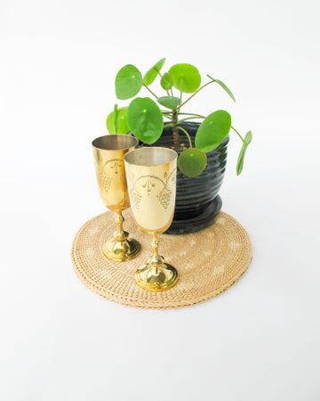 Two matching brass champagne flutes in a blue velvet box